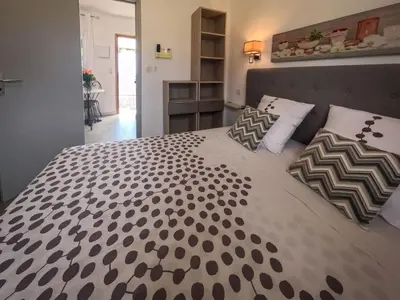 a large bed with black and white sheets and pillows at Holiday Home Ciriola by Interhome in Sari Solenzara