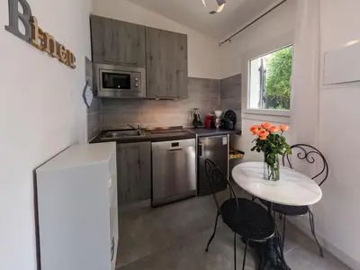 a small kitchen with a table with a vase of flowers at Holiday Home Ciriola by Interhome in Sari Solenzara