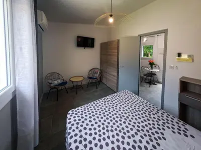 a bedroom with a bed and a table and chairs at Holiday Home Ciriola by Interhome in Sari Solenzara