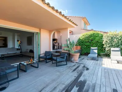 a patio with chairs and tables on a wooden deck at Holiday Home Verde by Interhome in Porto-Vecchio