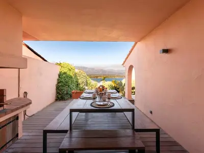 a table on a patio with a view of the water at Holiday Home Verde by Interhome in Porto-Vecchio