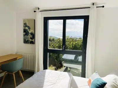 a bedroom with a bed and a window with a view at Villa Arazu, 10 personnes, piscine chauffée, vue mer, 15 minutes à pieds plage in Cirendinu