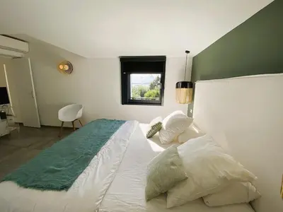 a bedroom with a large white bed with a window at Villa Arazu, 10 personnes, piscine chauffée, vue mer, 15 minutes à pieds plage in Cirendinu