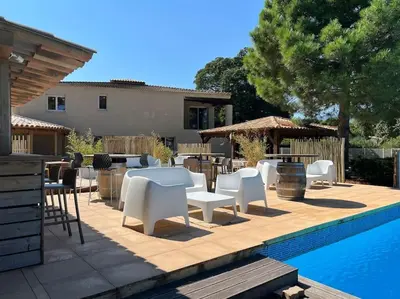 a patio with white tables and chairs next to a pool at Havre de paix Fiori di Cala Rossa in Lecci