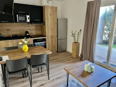 a kitchen and dining room with a table and chairs at Havre de paix Fiori di Cala Rossa in Lecci