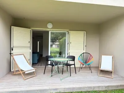 a patio with a table and chairs on a deck at Havre de paix Fiori di Cala Rossa in Lecci