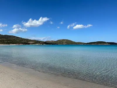 a view of a beach with mountains in the background at Mini villa T3 de 48m2 in Lecci