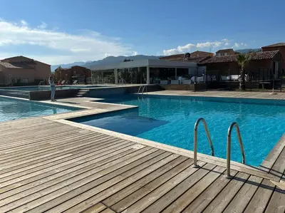 a large swimming pool with a person standing next to it at Mini villa T3 de 48m2 in Lecci