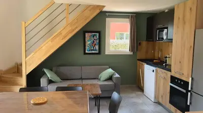 a kitchen and living room with a couch and a table at Mini villa T3 de 48m2 in Lecci