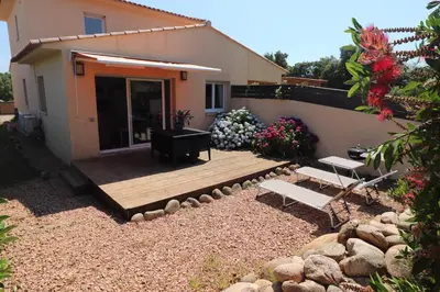 a backyard with a wooden deck and a house at Accommodation Close To Pinarello Beach in Conca