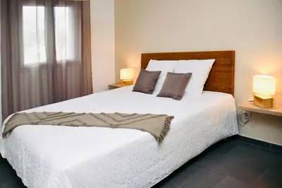 a bedroom with a large white bed with two lamps at Casa Serena in Linguizzetta