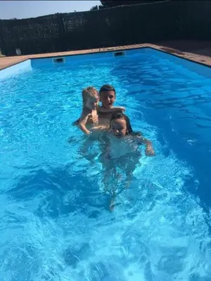 three people are swimming in a swimming pool at Casa Serena in Linguizzetta