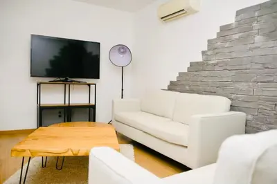 a living room with a white couch and a tv at Casa Serena in Linguizzetta