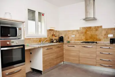 a kitchen with wooden cabinets and a sink and a microwave at Casa Serena in Linguizzetta