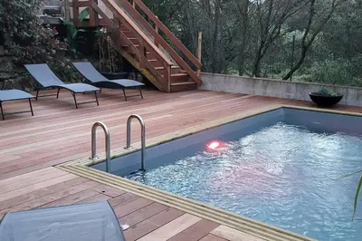 a swimming pool on a wooden deck with a staircase at Casa Marcelli 4 in Porto-Vecchio