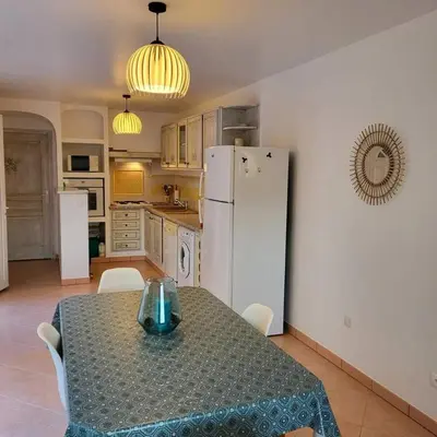 a kitchen with a table and a white refrigerator at Casa Marcelli 4 in Porto-Vecchio