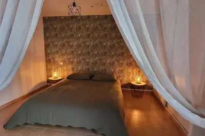 a bedroom with a bed with two lamps and curtains at Casa Marcelli 4 in Porto-Vecchio