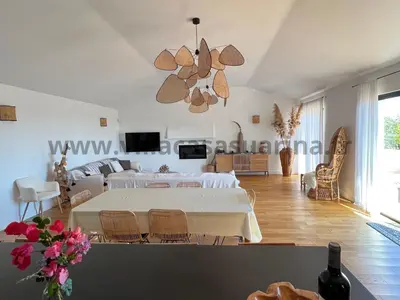 a living room with a white table and a couch at Villa vue mer, piscine chauffée à Porto Vecchio in Porto-Vecchio