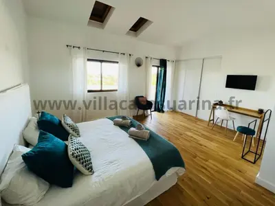 a bedroom with a large bed with blue pillows at Villa vue mer, piscine chauffée à Porto Vecchio in Porto-Vecchio