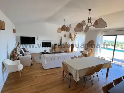 a living room with a couch and a table at Villa vue mer, piscine chauffée à Porto Vecchio in Porto-Vecchio