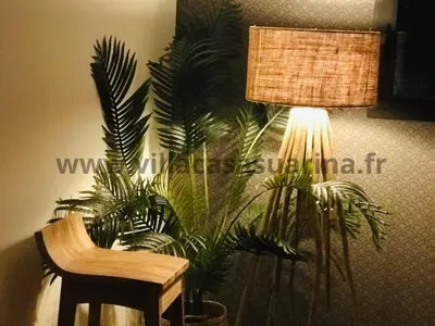 a lamp and a chair next to some plants at Villa vue mer, piscine chauffée à Porto Vecchio in Porto-Vecchio