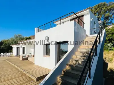 a villa with a staircase leading up to a house at Villa vue mer, piscine chauffée à Porto Vecchio in Porto-Vecchio