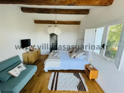a bedroom with a bed and a blue couch at Villa vue mer, piscine chauffée à Porto Vecchio in Porto-Vecchio