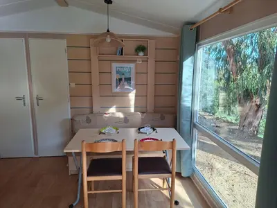 a dining room with a table and chairs and a window at Mira Monti Location in Belvédère