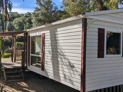 a white tiny house with a porch at Mira Monti Location in Belvédère