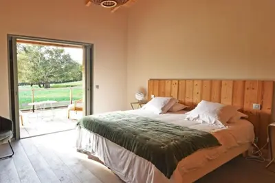 a bedroom with a large bed and a sliding glass door at Lodge Les Oliviers Di Lecci in Lecci