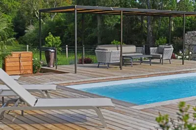 a wooden deck with chairs and a swimming pool at Lodge Les Oliviers Di Lecci in Lecci