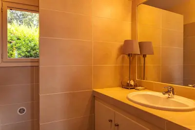 a bathroom with a sink and a mirror at Villa Pina in Sainte-Lucie de Porto-Vecchio