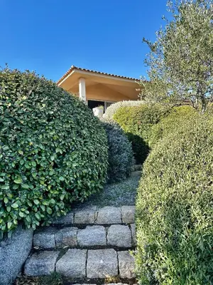 a stone path in front of a house with bushes at Villa Pina in Sainte-Lucie de Porto-Vecchio