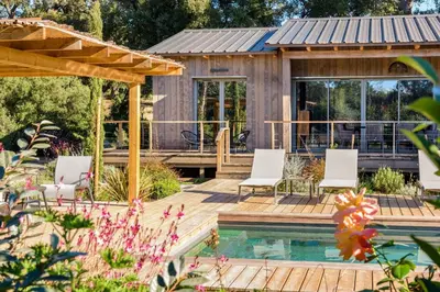 a house with a wooden deck and a swimming pool at Lodge La Myrte Di Lecci in Lecci