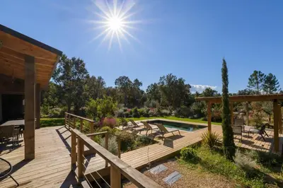 a wooden deck with a pool in a yard at Lodge La Myrte Di Lecci in Lecci