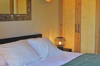 a bedroom with a bed with a mirror and a lamp at Lodge La Myrte Di Lecci in Lecci