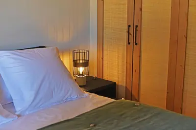 a bedroom with a bed with a lamp on a table at Lodge Les Arbousiers Di Lecci in Lecci