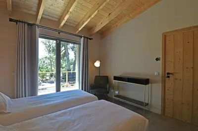 a bedroom with a bed and a window and a chair at Lodge Les Arbousiers Di Lecci in Lecci