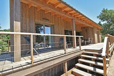 a home with a large deck with chairs on it at Lodge Les Arbousiers Di Lecci in Lecci