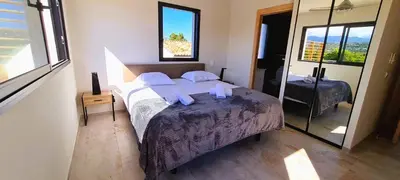 a bedroom with a large bed and a mirror at Villa Florida, 8 pers, vue montagne, 350 m plage à pieds in Pinarellu