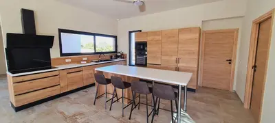 a kitchen with a table and chairs and a television at Villa Florida, 8 pers, vue montagne, 350 m plage à pieds in Pinarellu