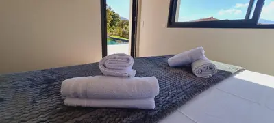 two towels and two rolled towels on a bed at Villa Florida, 8 pers, vue montagne, 350 m plage à pieds in Pinarellu