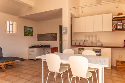 a kitchen and dining room with a table and chairs at Villa A signoria in Porto-Vecchio