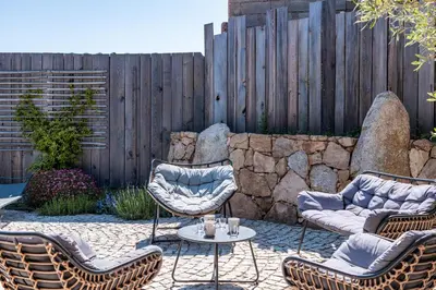 a patio with chairs and a table and a fence at Casetta Taglio Rosso Di Santa Lucia in Sainte-Lucie de Porto-Vecchio