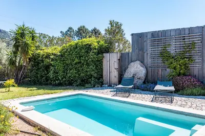 a swimming pool with two chairs and a fence at Casetta Taglio Rosso Di Santa Lucia in Sainte-Lucie de Porto-Vecchio