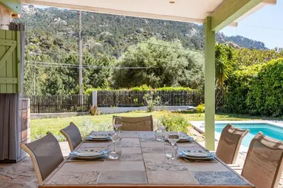 a table and chairs on a patio with a pool at Casetta Taglio Rosso Di Santa Lucia in Sainte-Lucie de Porto-Vecchio