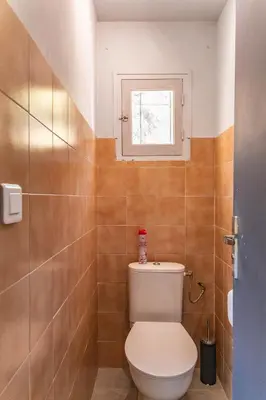 a bathroom with a toilet and a window at Casetta Taglio Rosso Di Santa Lucia in Sainte-Lucie de Porto-Vecchio
