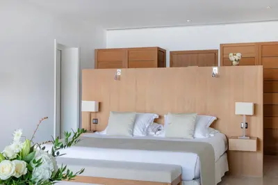 a bedroom with a large bed with a wooden headboard at Casadelmar in Porto-Vecchio