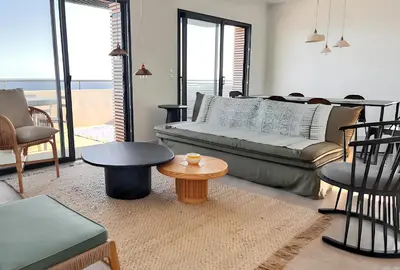 a living room with a couch and a table at Appartement spacieux à Cargèse avec terrasse vue mer in Cargèse