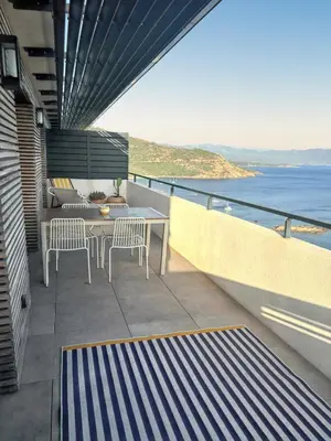 a balcony with a table and chairs and the ocean at Appartement spacieux à Cargèse avec terrasse vue mer in Cargèse